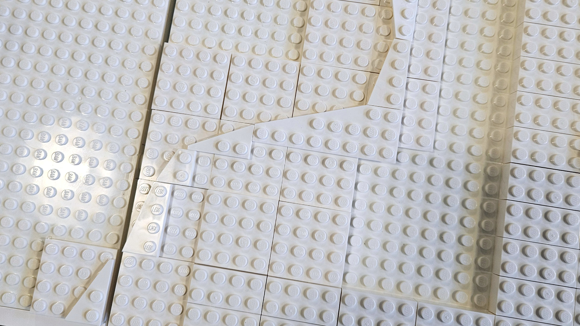 Terrain construction progressing across modular LEGO baseplates